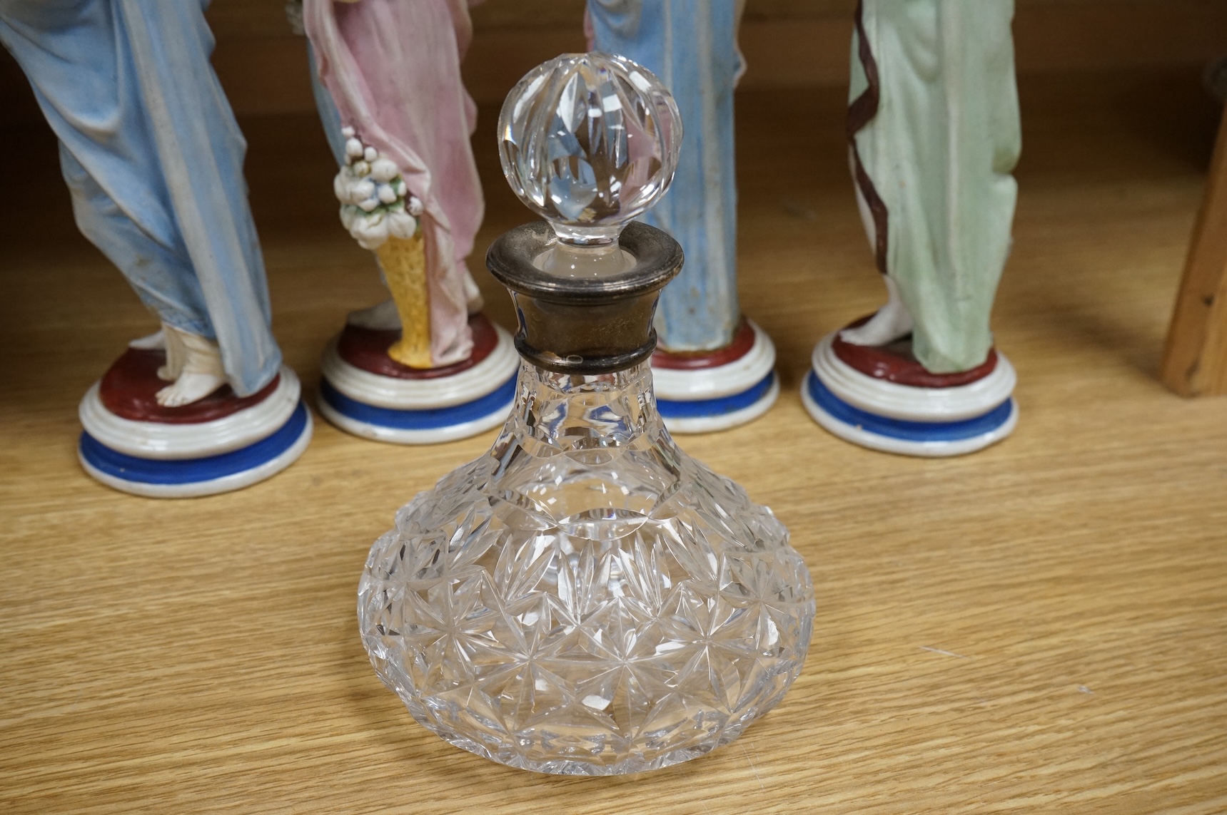 A set of four painted biscuit porcelain figures of The Seasons, and a silver-mounted scent bottle, figures 24cm